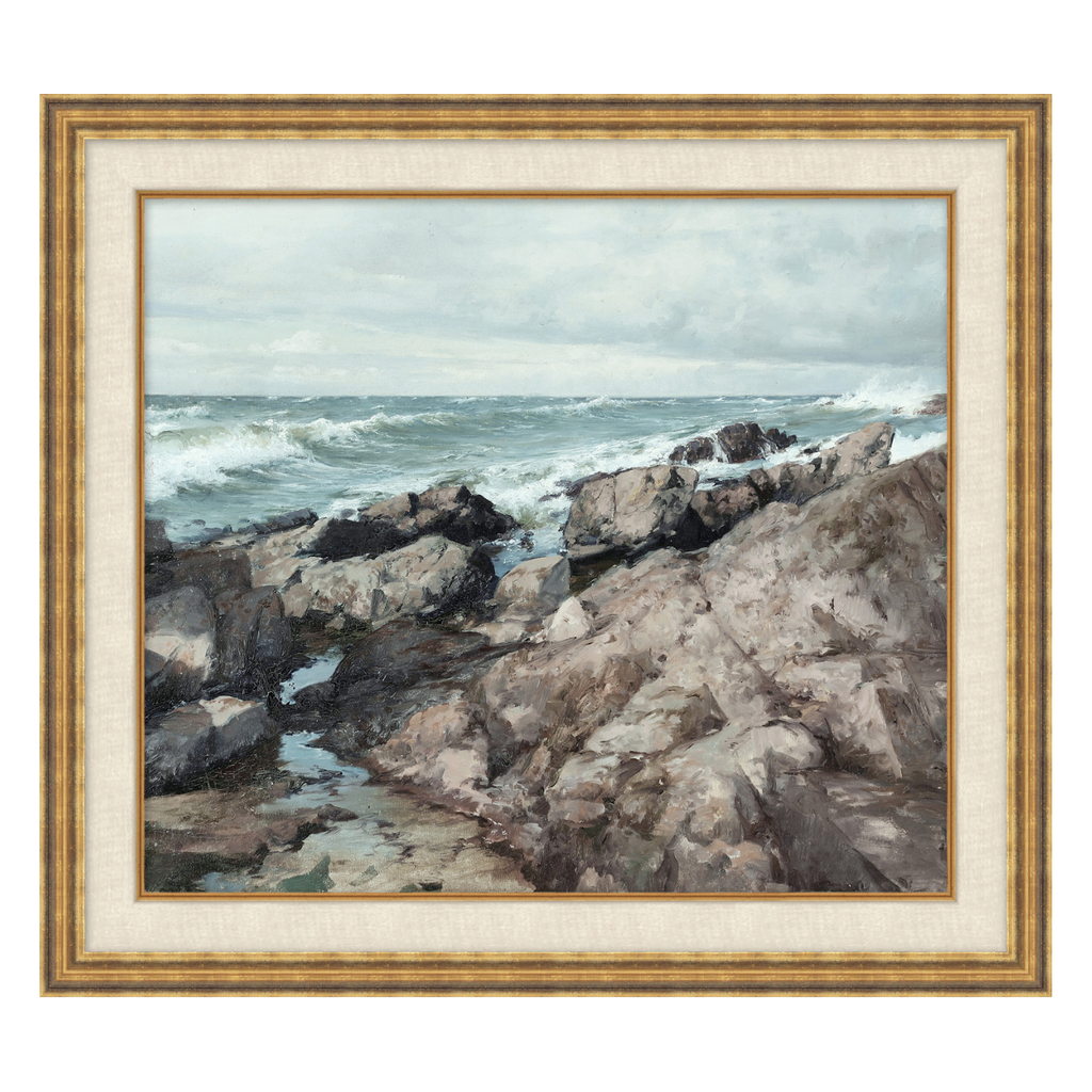 Framed artwork of a coastal scene with rocks and ocean waves.